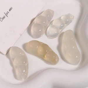 Vue détaillée de cinq pendentifs haricots en agate naturelle dans un plat blanc