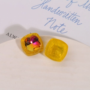 Dettaglio macro di ciondoli quadrati in resina glitterata con strass per creazioni di gioielli
