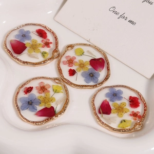 Detailed macro view of round gold pendants with real dried flowers for DIY jewelry making