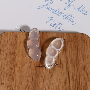 Vue macro de breloques en agate translucide en forme de cosse de pois pour bijoux DIY