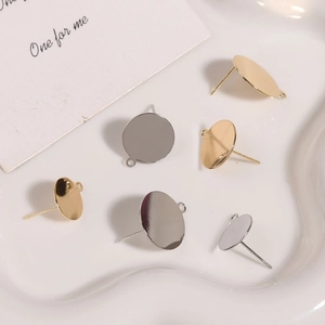 Detailed view of S925 silver and gold plated earring studs with hanging loops on ceramic