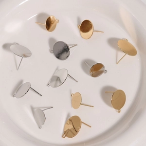 Gold and silver DIY earring posts with loops for jewelry making on white dish