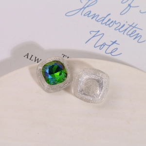 Dettaglio di gemma quadrata sfumata blu-verde in base di resina glitterata