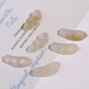 Détail de six pendentifs en jade translucide sur un fond de papier d'art