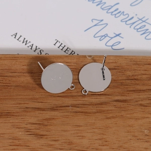 Detailed view of silver post earrings with flat round base and loop for DIY jewelry making