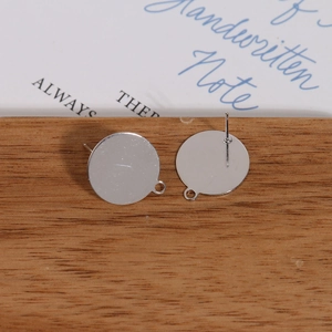 Detail shot of gold-plated flat round stud earring components with small hanging loops