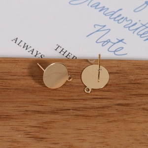 Macro detail of gold plated flat round earring studs with loop for DIY jewelry making