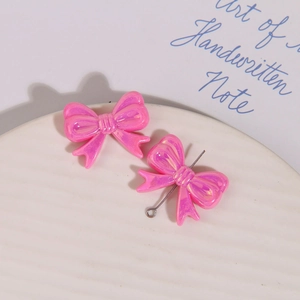 Vue macro de la perle noeud en résine rose irisée avec tige métallique pour bijoux DIY