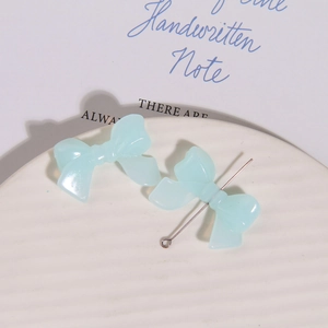 Detail van lichtblauwe doorschijnende hars strikbedeltjes voor DIY oorbellen en accessoires