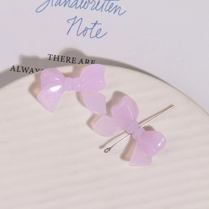 Detail van lichtpaarse hars strik bedel met metalen pin voor DIY oorbellen sieraden