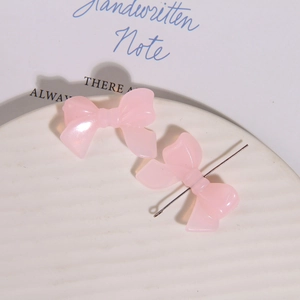 Detail van roze parelmoer harsstrikjes met metalen pin voor DIY oorbellen maken