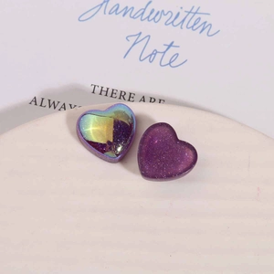 Vue macro de breloques en résine violette pailletée pour bijoux DIY et artisanat