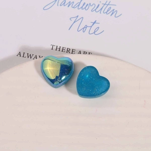 Gros plan de breloques cœur en résine bleue pailletée pour boucles d'oreilles DIY