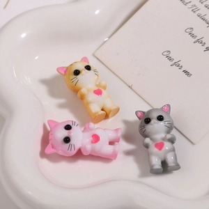 Vista dettagliata di ciondoli gatto 3D in resina rosa, gialla e grigia con piccoli cuori