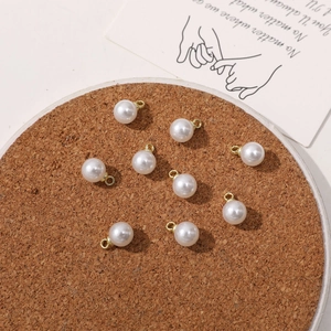 Set of nine white faux pearl charms with golden rings for DIY jewelry craft making