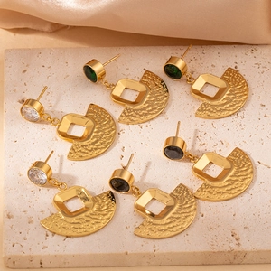 Close-up of three pairs of vintage geometric fan earrings in white, green and black