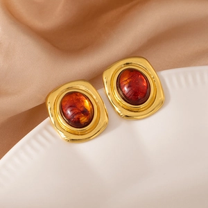 Vista macro de pendientes vintage de oro con piedra de ámbar y marco elegante