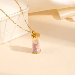 Detail of a gold glass bottle necklace filled with colorful heart-shaped natural stones