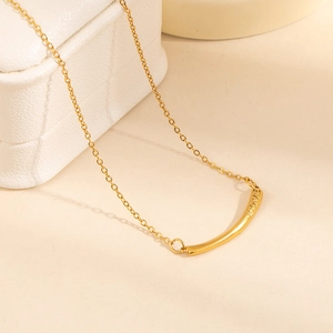 Dettaglio della collana in acciaio dorato con incisione LOVE su scatola per gioielli