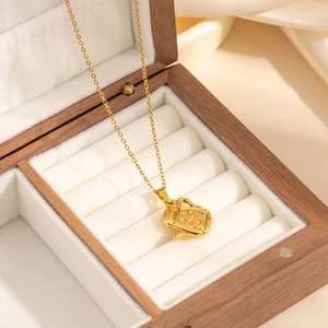 Dettaglio di una collana con ciondolo a teiera d'oro in una scatola per gioielli