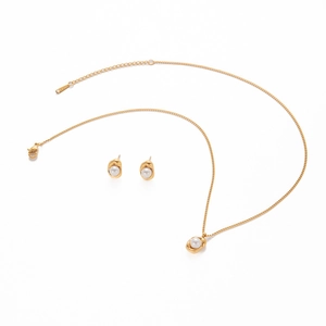 Detail of gold stainless steel necklace and pearl earrings set with lobster clasp