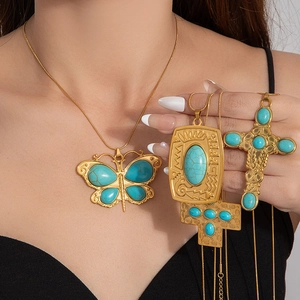 Detailed shot of retro gold pendants with turquoise stones and butterfly motif