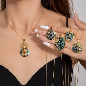 Detail of vintage gold plated flower necklaces with blue enamel and bohemian designs