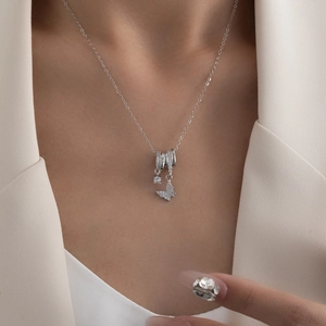 Detail der silbernen Stahlhalskette mit Schmetterlingsanhänger und Zirkonia an einem Model