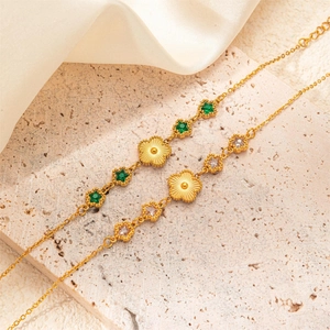 Elegant gold titanium bracelet with emerald zircon flower and star pendants on a stone base