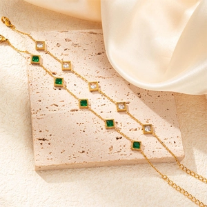 Detail of vintage gold bracelets featuring emerald green and clear cubic zirconia stones
