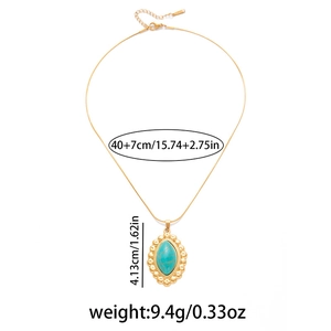 Detail of gold necklace showing a green turquoise pendant with size measurements