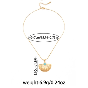Detail of fan-shaped pendant with blue stone on gold-tone stainless steel snake chain