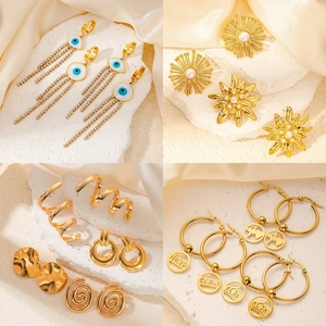 Macro detail of assorted gold plated titanium earrings with pearls and crystal accents