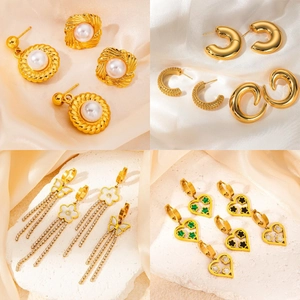 Detail of four gold earrings featuring pearls, butterfly tassels and heart charms