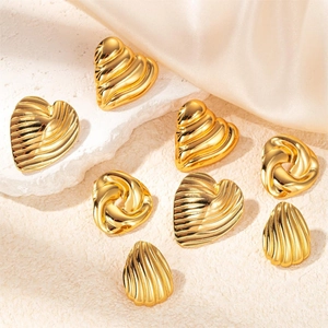 Detailed view of gold-plated titanium steel wing earrings with heart and shell textures
