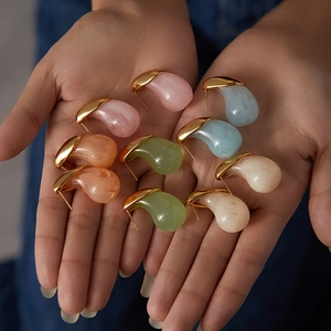 Orecchini a goccia in acciaio inossidabile mostrati sulla mano in vari colori pastello