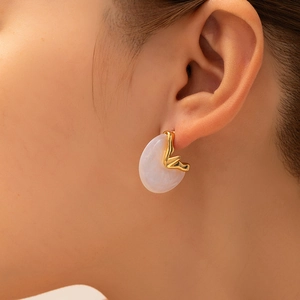 Orecchini geometrici color oro con resina traslucida indossati da una modella