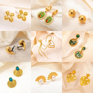 Collage aus vergoldeten Ohrringen und Schmuck auf beigem Seidenhintergrund