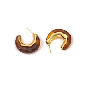 Minimalist wave-shaped earrings with gold metal and amber resin in a C-curve style