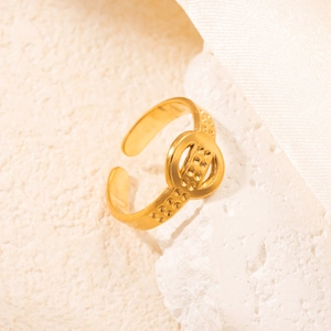Dettaglio dell'anello dorato regolabile con doppie fasce e trama a piccoli punti