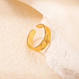 Dettaglio anello in acciaio placcato oro 18k con goffratura a raggiera su pietra e seta