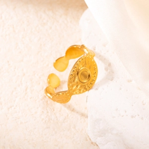 Dettaglio anello regolabile dorato con texture martellata su supporto minerale bianco