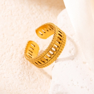 Dettaglio anello largo in acciaio placcato oro 18k con motivo traforato su pietra