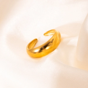 Dettaglio dell'anello irregolare placcato oro 18k su tessuto di seta bianca lucida