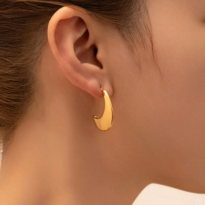 Close-up of elegant 18K gold plated teardrop earrings worn by a model in soft light