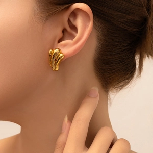 Close-up of 18K gold-plated geometric titanium steel earring worn by a model