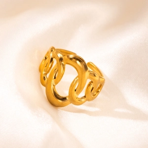 Macro di un anello a catena ritorta dorata su un lussuoso tessuto di raso giallo tenue