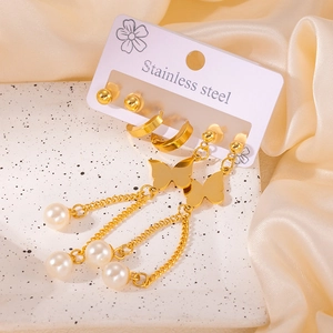 Détails d'un ensemble de boucles d'oreilles en acier doré avec papillons et perles