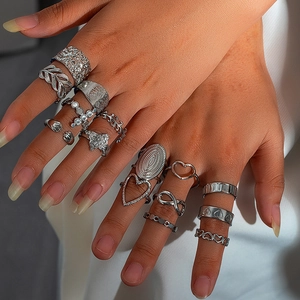 Detail view of silver hollow heart and leaf rings set worn on fingers for bohemian style