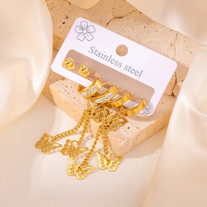 Détail de boucles d'oreilles en acier doré avec chaînes papillon sur présentoir